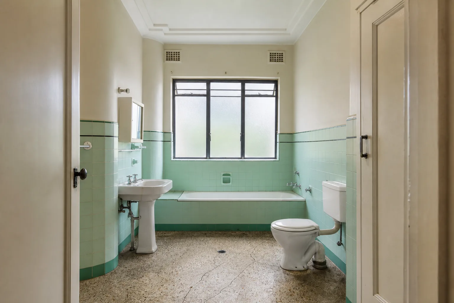 Representative Art Deco apartment bathroom concept before renovation with mint tiles
