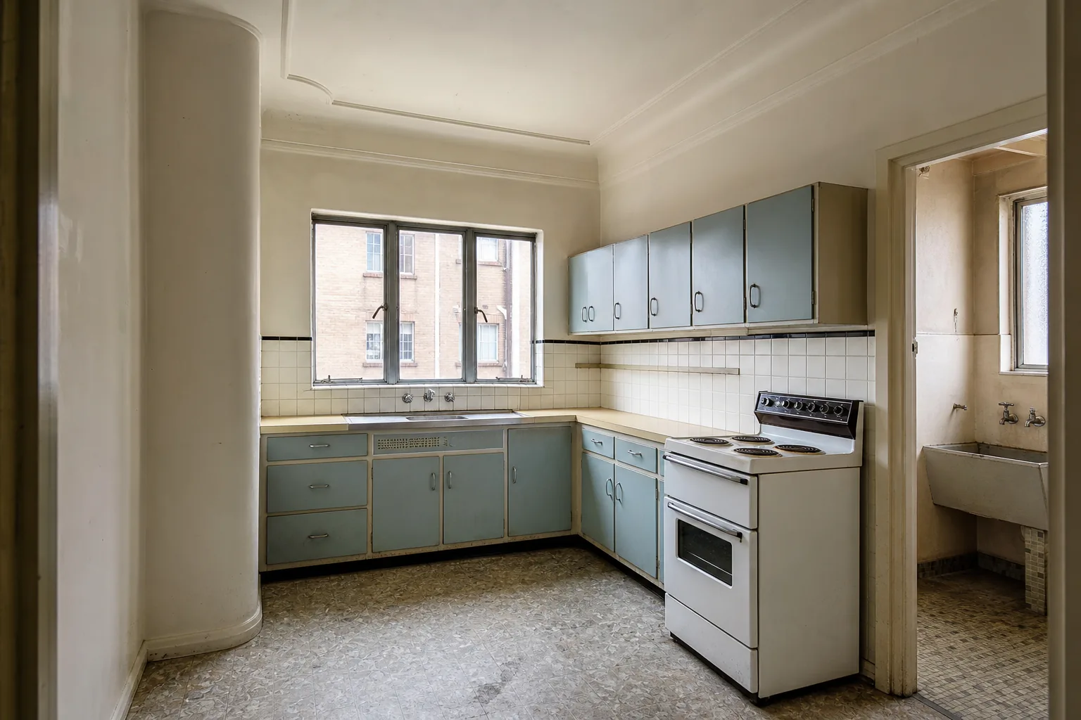 Representative Art Deco apartment kitchen concept before renovation with blue cabinetry